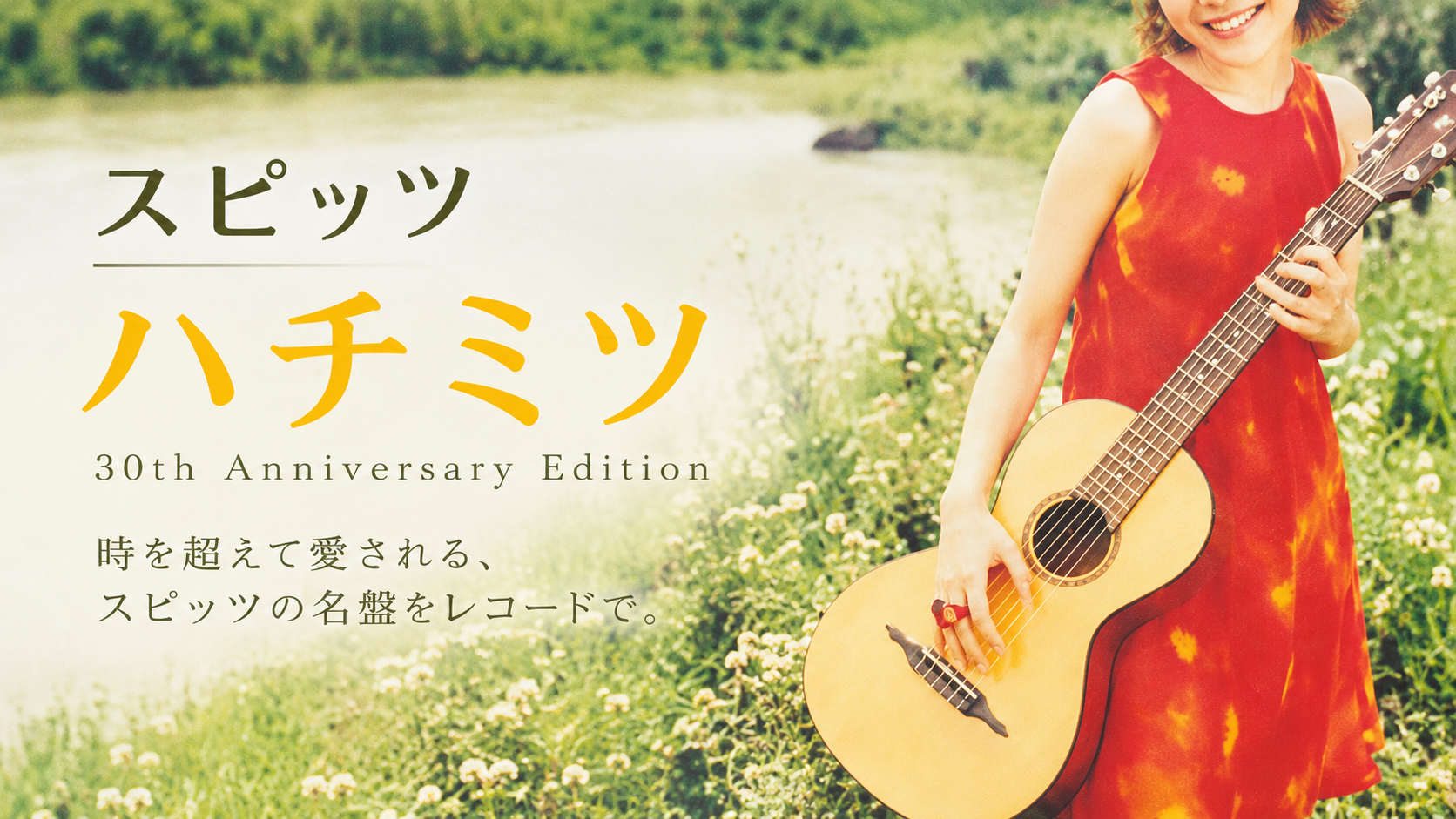緑の野原で赤いワンピース姿の人物がギターを持ち、「スピッツ ハチミツ 30th Anniversary Edition」と記したイメージ画像